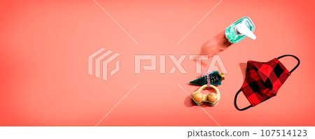 Face mask and a sanitizer bottle with a toy car carrying a Christmas tree Face mask and a sanitizer bottle with a toy car carrying a Christmas tree 107514123
