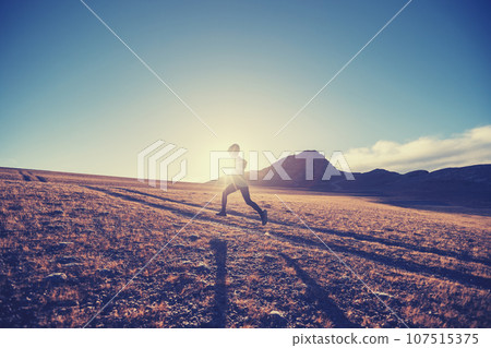 Woman trail runner cross country running in sunset 107515375