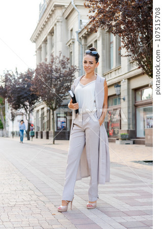 Successful businessman or entrepreneur smiling holding notepad while walking 107515708