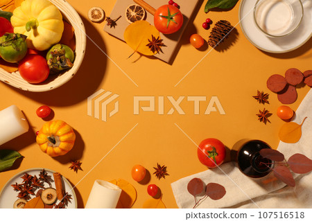 Pumpkins and tomatoes arranged with candles, cup of milk and a white towel. Vacant space in the middle for product advertising. Thanksgiving day concept 107516518