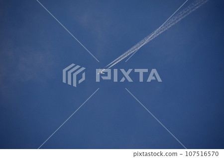 Airplane and contrails flying in the blue sky Airplane and contrails flying in the blue sky 107516570
