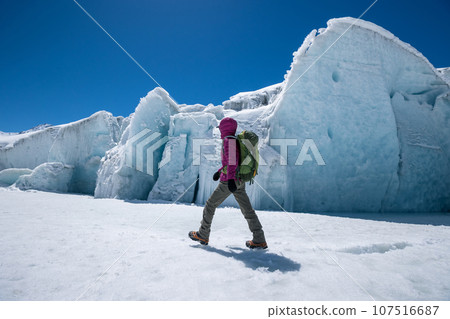 Woman hiker hiking in winter huge glacier mountain,China Woman hiker hiking in winter huge glacier mountain,China 107516687