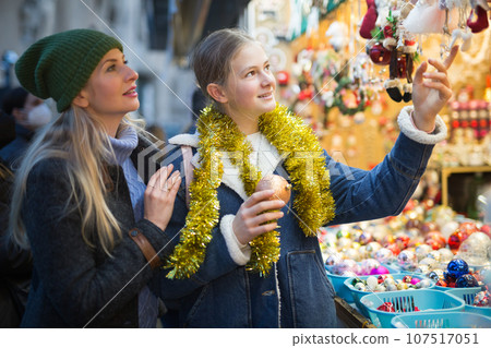 Winter holidays and celebration concept - happy mother and teenager daughter at christmas market closeup 107517051