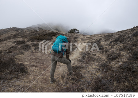 Woman hiker hiking at mountain top in tibet 107517199