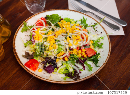 Appetizing salad with corn, arugula and tomatoes on plate Appetizing salad with corn, arugula and tomatoes on plate 107517329