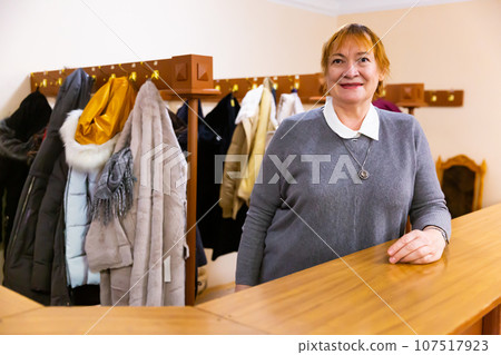 Portrait of senior woman working in cloakroom in museum Portrait of senior woman working in cloakroom in museum 107517923