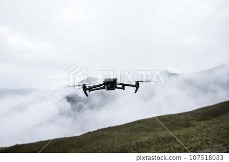 Flying drone in high altitude mountains Flying drone in high altitude mountains 107518083