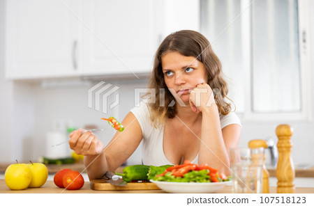 Portrait of disappointed woman cooking at home kitchen Portrait of disappointed woman cooking at home kitchen 107518123