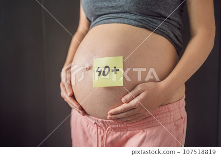 Radiant and confident, a woman in her 40s embraces pregnancy, defying age stereotypes and celebrating the beauty of motherhood 107518819