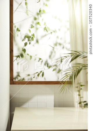A comfortable room where warm afternoon sunlight comes in through a window with a view of tree leaves. 107520340