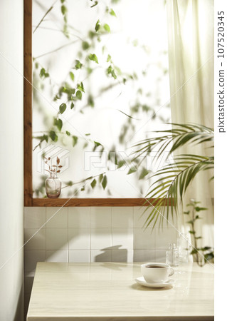 A comfortable room where warm afternoon sunlight comes in through a window with a view of tree leaves. A comfortable room where warm afternoon sunlight comes in through a window with a view of tree leaves. 107520345