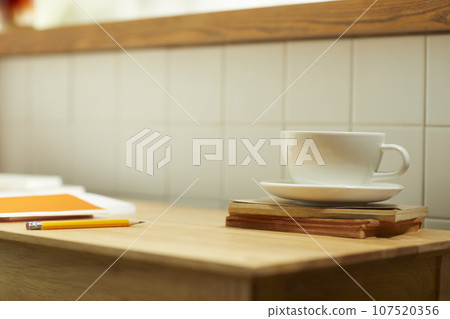 A comfortable room where warm afternoon sunlight comes in through a window with a view of tree leaves. 107520356