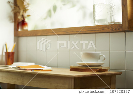 A comfortable room where warm afternoon sunlight comes in through a window with a view of tree leaves. 107520357