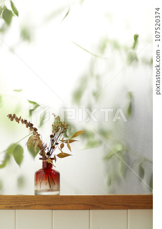 A comfortable room where warm afternoon sunlight comes in through a window with a view of tree leaves. 107520374