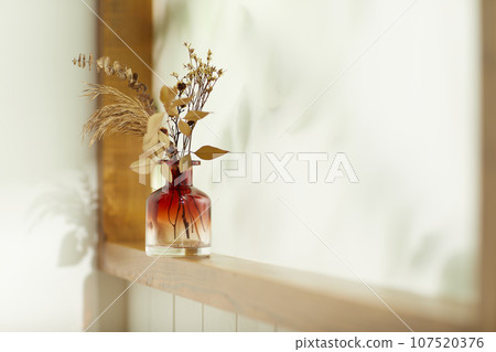A comfortable room where warm afternoon sunlight comes in through a window with a view of tree leaves. A comfortable room where warm afternoon sunlight comes in through a window with a view of tree leaves. 107520376