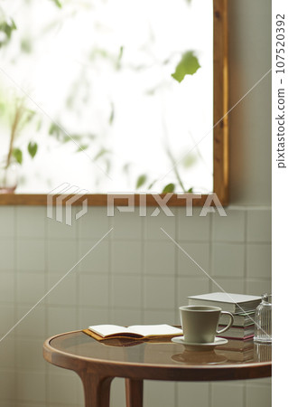 A comfortable room where warm afternoon sunlight comes in through a window with a view of tree leaves. A comfortable room where warm afternoon sunlight comes in through a window with a view of tree leaves. 107520392