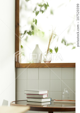 A comfortable room where warm afternoon sunlight comes in through a window with a view of tree leaves. A comfortable room where warm afternoon sunlight comes in through a window with a view of tree leaves. 107520399