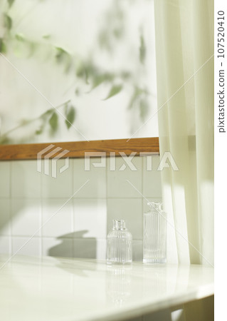 A comfortable room where warm afternoon sunlight comes in through a window with a view of tree leaves. A comfortable room where warm afternoon sunlight comes in through a window with a view of tree leaves. 107520410
