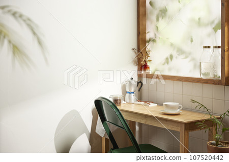 A comfortable room where warm afternoon sunlight comes in through a window with a view of tree leaves. A comfortable room where warm afternoon sunlight comes in through a window with a view of tree leaves. 107520442
