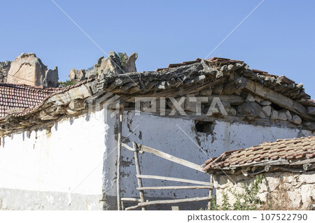 Old broken roof of a village house with white walls Old broken roof of a village house with white walls 107522790