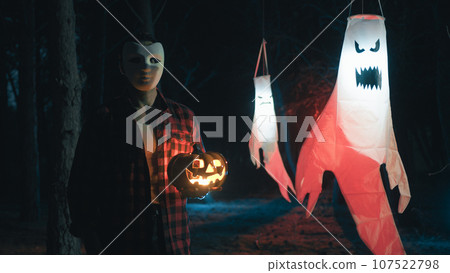 Masked man with halloween pumpkin walk in the forest 107522798