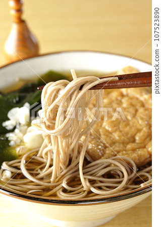 Kitsune soba with two pieces of fried tofu, seaweed, and green onion 107523890