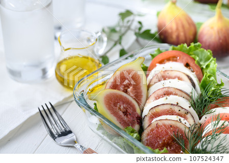 Italian Cuisine Caprese with fresh figs, tomatoes and mozzarella cheese Italian Cuisine Caprese with fresh figs, tomatoes and mozzarella cheese 107524347