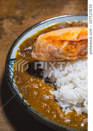 Curry topped with grilled salmon 107525616