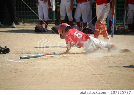 Elementary school student playing sliding baseball 107525787