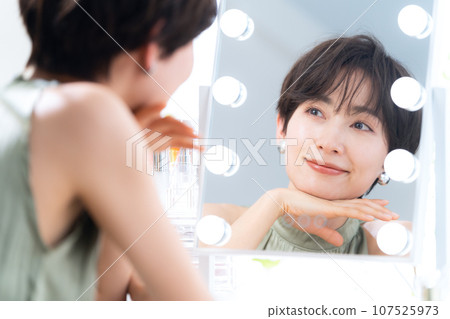 Middle-aged woman applying makeup in the makeup room 107525973