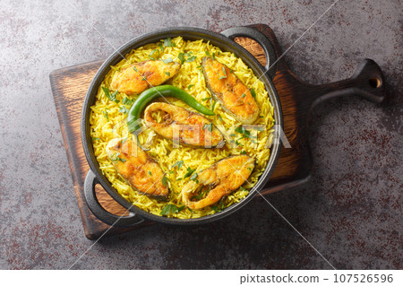Bengali style Fish Pilaf cooked with Ilish Fish closeup on the black pan. Horizontal top view Bengali style Fish Pilaf cooked with Ilish Fish closeup on the black pan. Horizontal top view 107526596