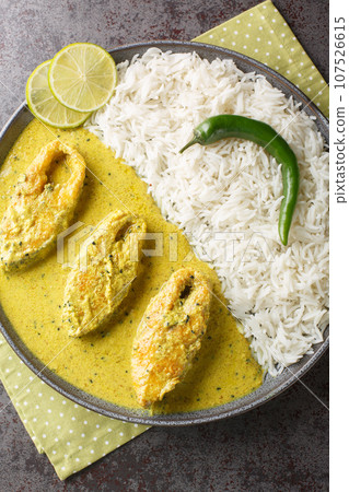 Traditional Mustard Fish Curry Shorshe Ilish or Hilsa closeup on the plate on the table. Vertical top view 107526615