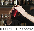 barkeeper mixing drinks together in a bar 107528252