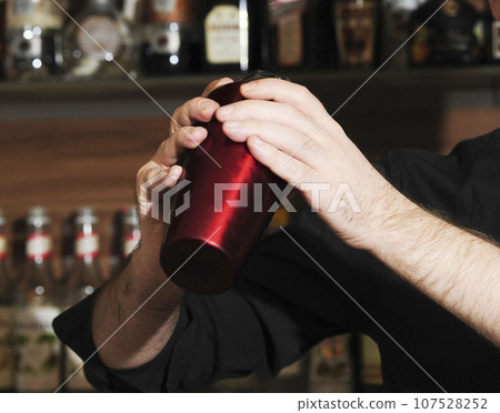 barkeeper mixing drinks together in a bar barkeeper mixing drinks together in a bar 107528252