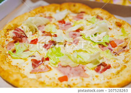carbonara pizza cut into pieces.  107528263