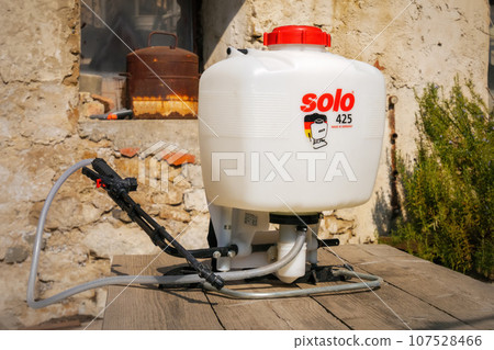Backpack sprayer Solo 425 on a wooden table in the backyard. Backpack sprayer Solo 425 on a wooden table in the backyard. 107528466