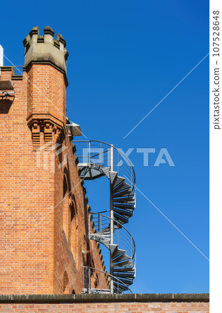 red brick building with staircase and tower 107528648