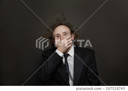 Shocked businessman on black background, studio portrait Shocked businessman on black background, studio portrait 107528745
