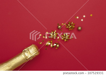 Champagne bottle with confetti stars on color background, space for text Champagne bottle with confetti stars on color background, space for text 107529331