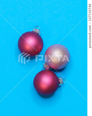 three christmas balls on turquoise background 107530746