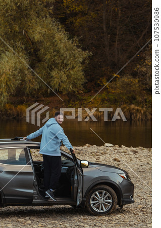 man car traveler stop at river rocky beach enjoying the autumn forest 107530986