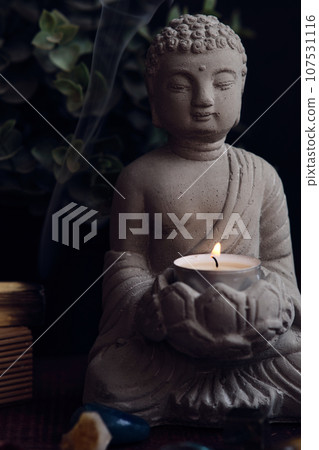 stone statue of buddha with a candle stone statue of buddha with a candle 107531116