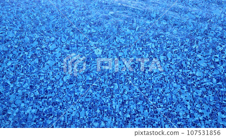 The bottom of a swimming pool made of multi-colored tiles under a layer of water The bottom of a swimming pool made of multi-colored tiles under a layer of water 107531856