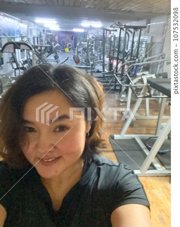 Gym Glow: Asian Woman Captures Fitness Achievement in a Selfie 107532098