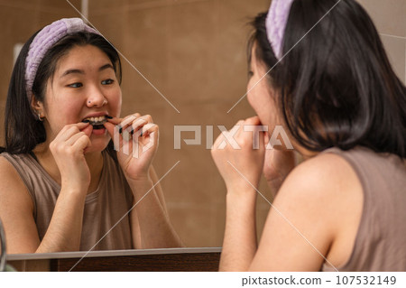 Guarding Her Smile: Asian Girl Demonstrates Proper MouthGuard Use. Night bite correction 107532149