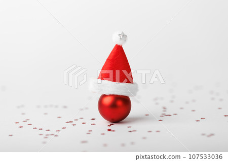 Christmas ball with Christmas hat on white background Christmas ball with Christmas hat on white background 107533036