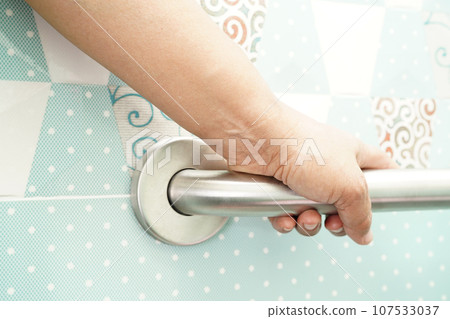 Asian woman patient use toilet support rail in bathroom, handrail safety grab bar, security in nursing hospital. Asian woman patient use toilet support rail in bathroom, handrail safety grab bar, security in nursing hospital. 107533037