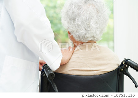 Doctor help Asian elderly woman disability patient sitting on wheelchair in hospital, medical concept. Doctor help Asian elderly woman disability patient sitting on wheelchair in hospital, medical concept. 107533130