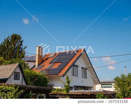 Solar photovoltaic panels on house roof. Modern country house with self-sustaining energy system. Suburb of Vienna, Austria. Idea harnessing clean and sustainable energy, saving money on electricity 107533336