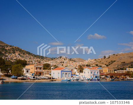 Symi Island, Greece. Greece islands holidays from Rhodos in Aegean Sea. Colorful neoclassical houses in bay of Symi. Holiday travel background. 107533346